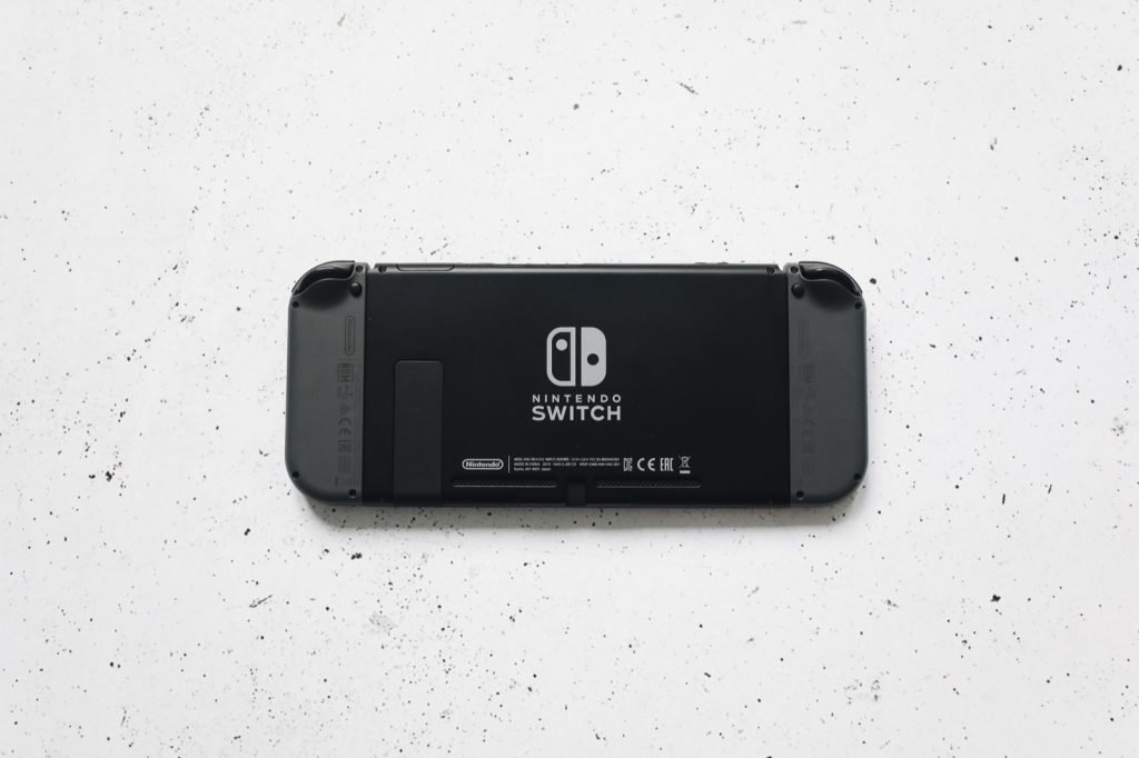 The rear of a Nintendo Switch console lying on a pale speckled surface