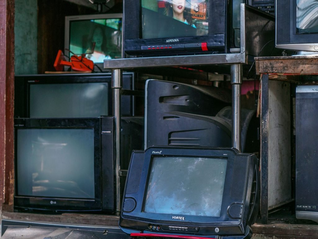 Stacked used televisions and dead consumer electronics filling a back room