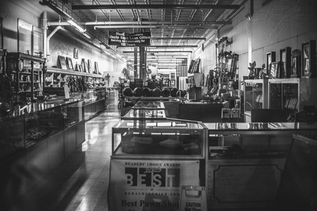 Interior of a pawn shop with glass display cases and shelved merchandise