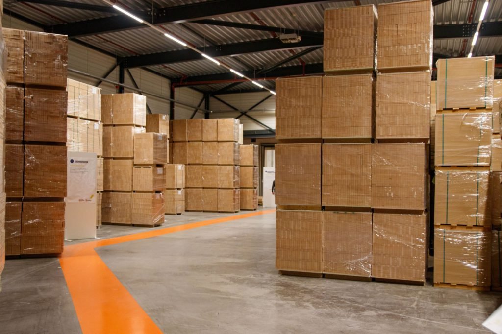 Shrink-wrapped pallet stacks lining the floor of a receiving warehouse