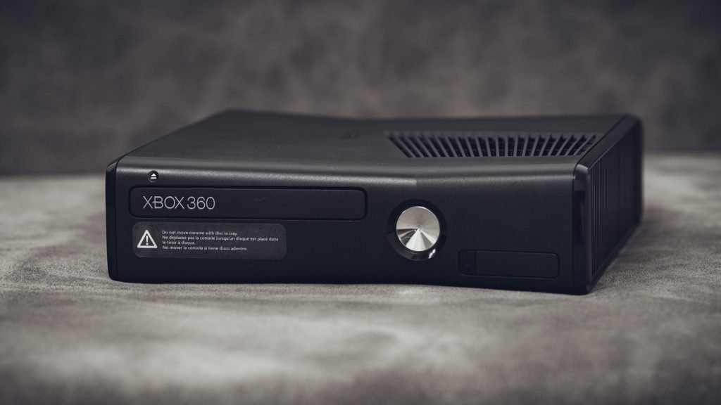 A black Xbox 360 console standing on a grey surface